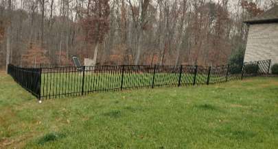 a field with a black aluminum fence